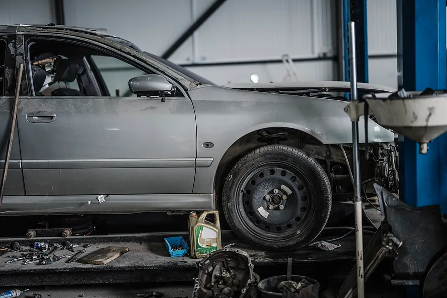 Car partly disassembled in a repair bay during a diagnostic teardown